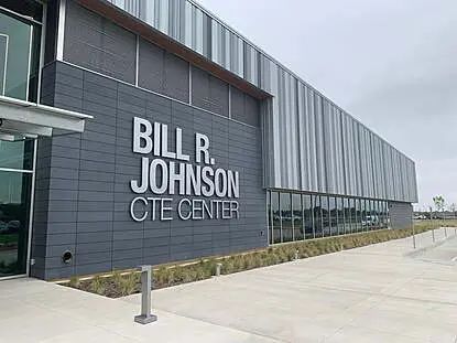 Bill Johson CTE Center Modern educational building with metal paneling and large signage reading 'Bill R. Johnson CTE Center,' featuring a clean concrete walkway and landscaped exterior.