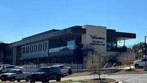 Palo Verde Modern commercial building featuring the Via 313 and Tex Mex signage, with large glass windows, an upper-level patio, and vehicles parked in the foreground.